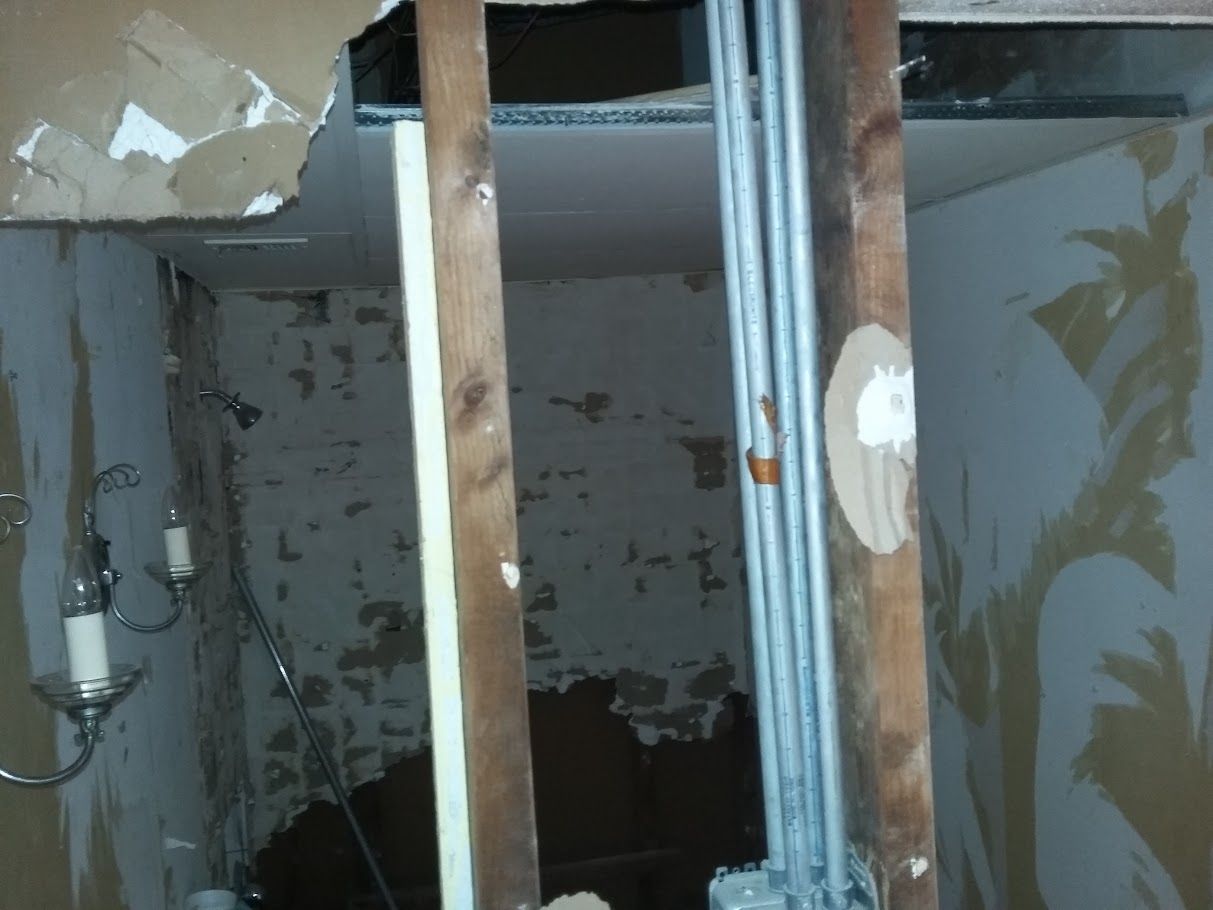 A room that is being remodeled with a chandelier hanging from the ceiling