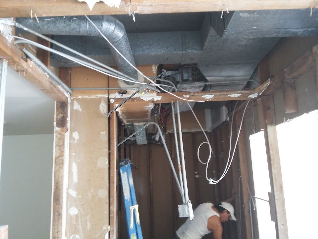 A man is working on the ceiling of a building.