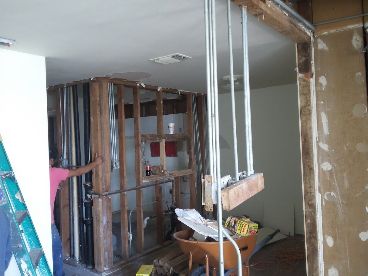 A man is standing in a room with a ladder.