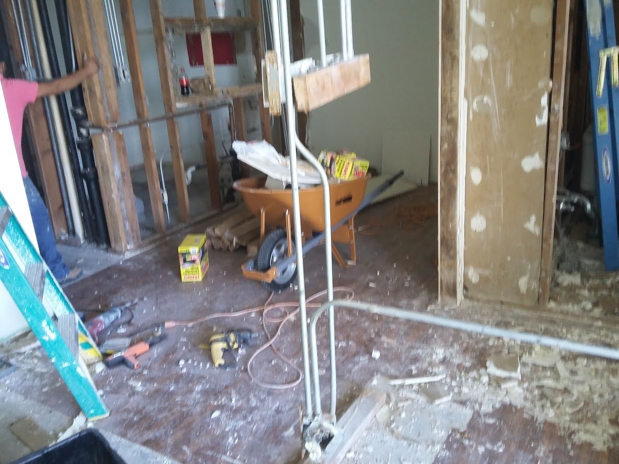 A room with a wheelbarrow and a ladder in it