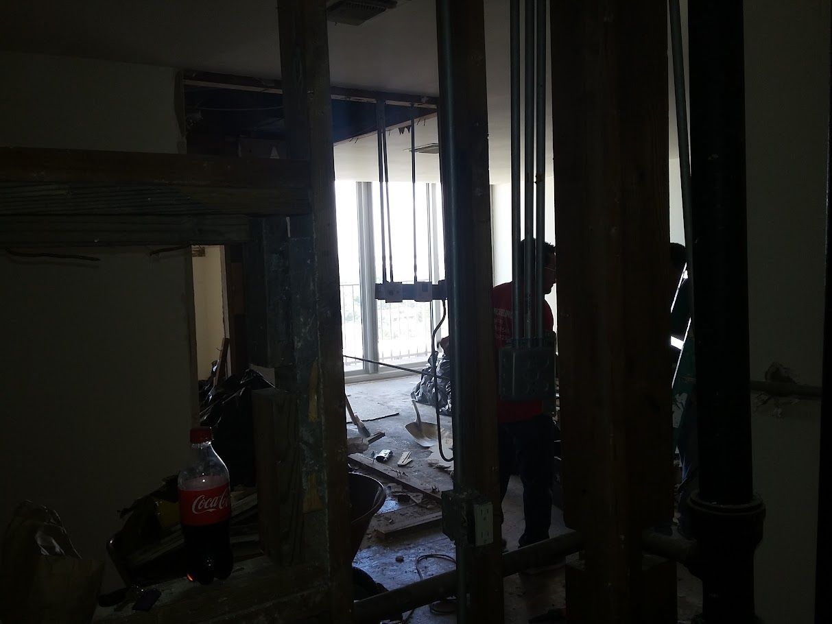 A bottle of coca cola is sitting on the floor in a dark room.