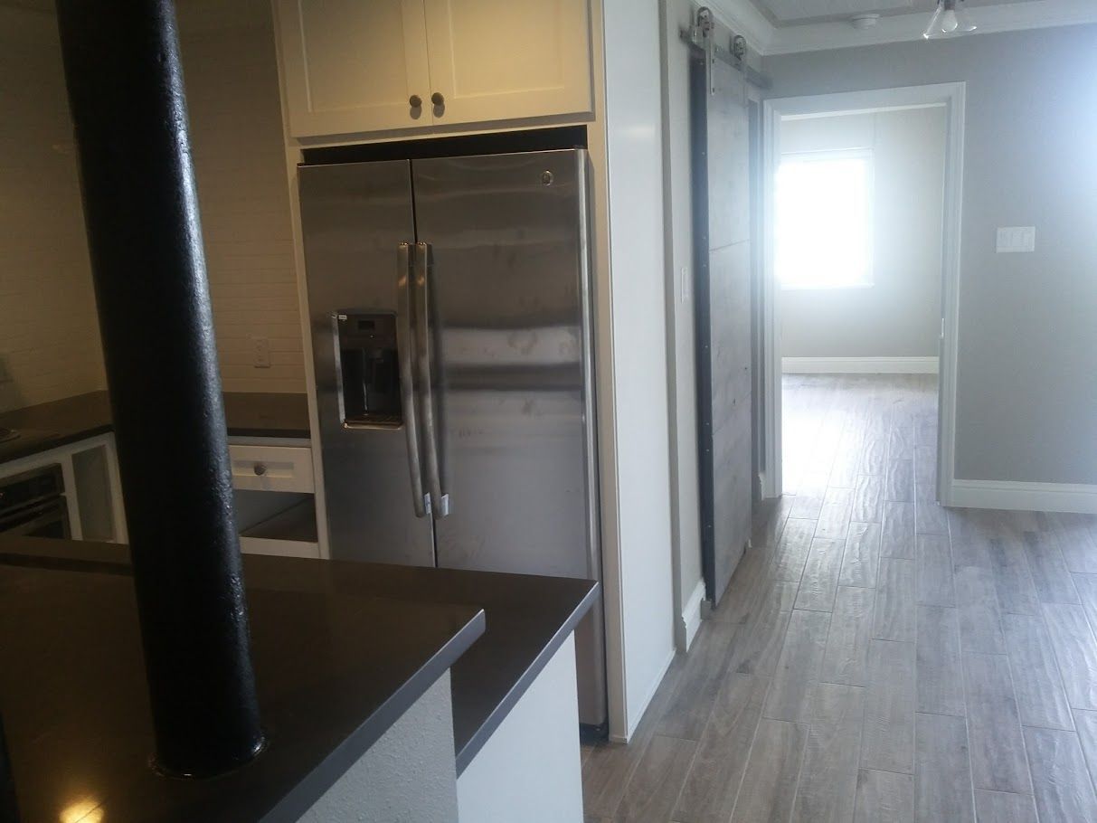 An empty kitchen with a stainless steel refrigerator