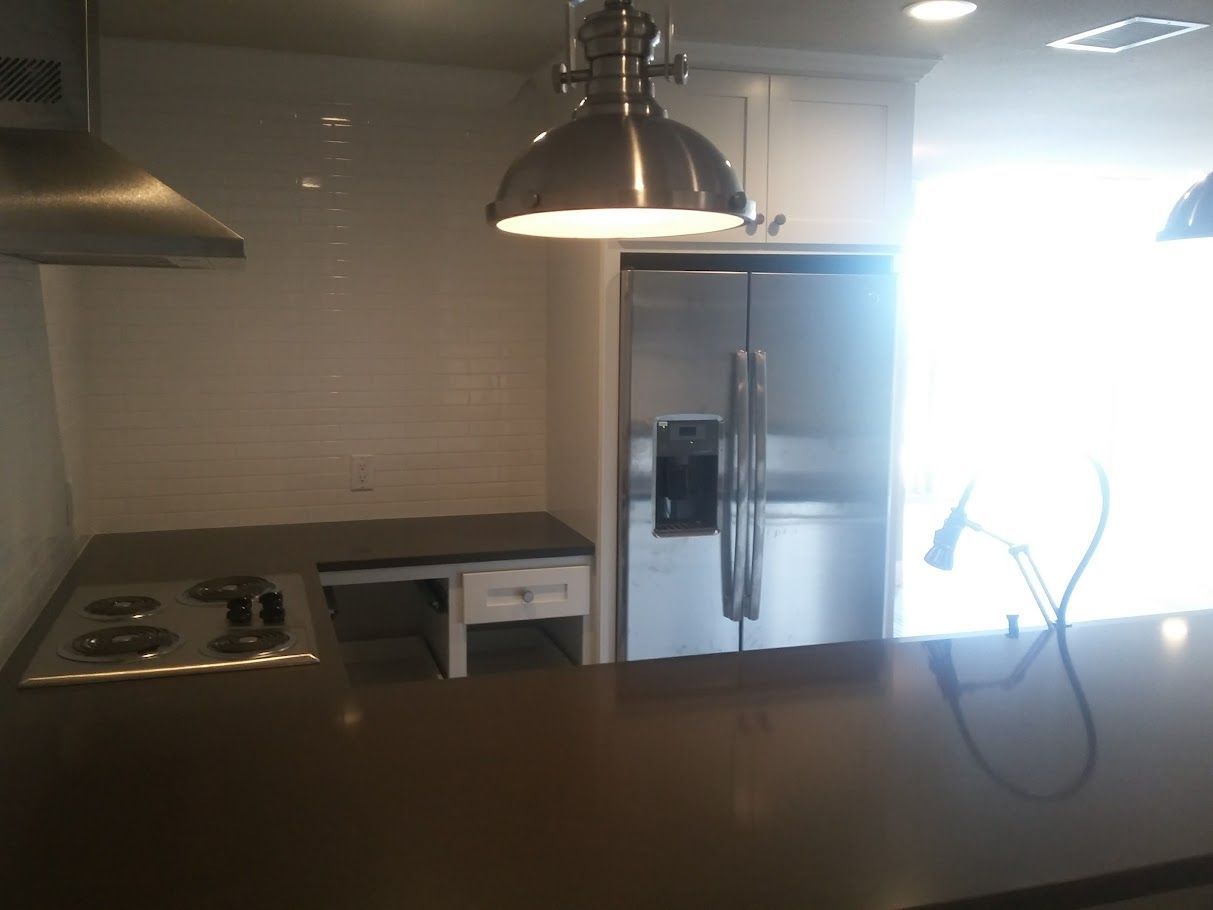 A kitchen with a stove top oven and a refrigerator