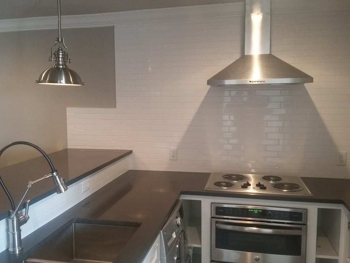 A kitchen with a stove top oven and a sink
