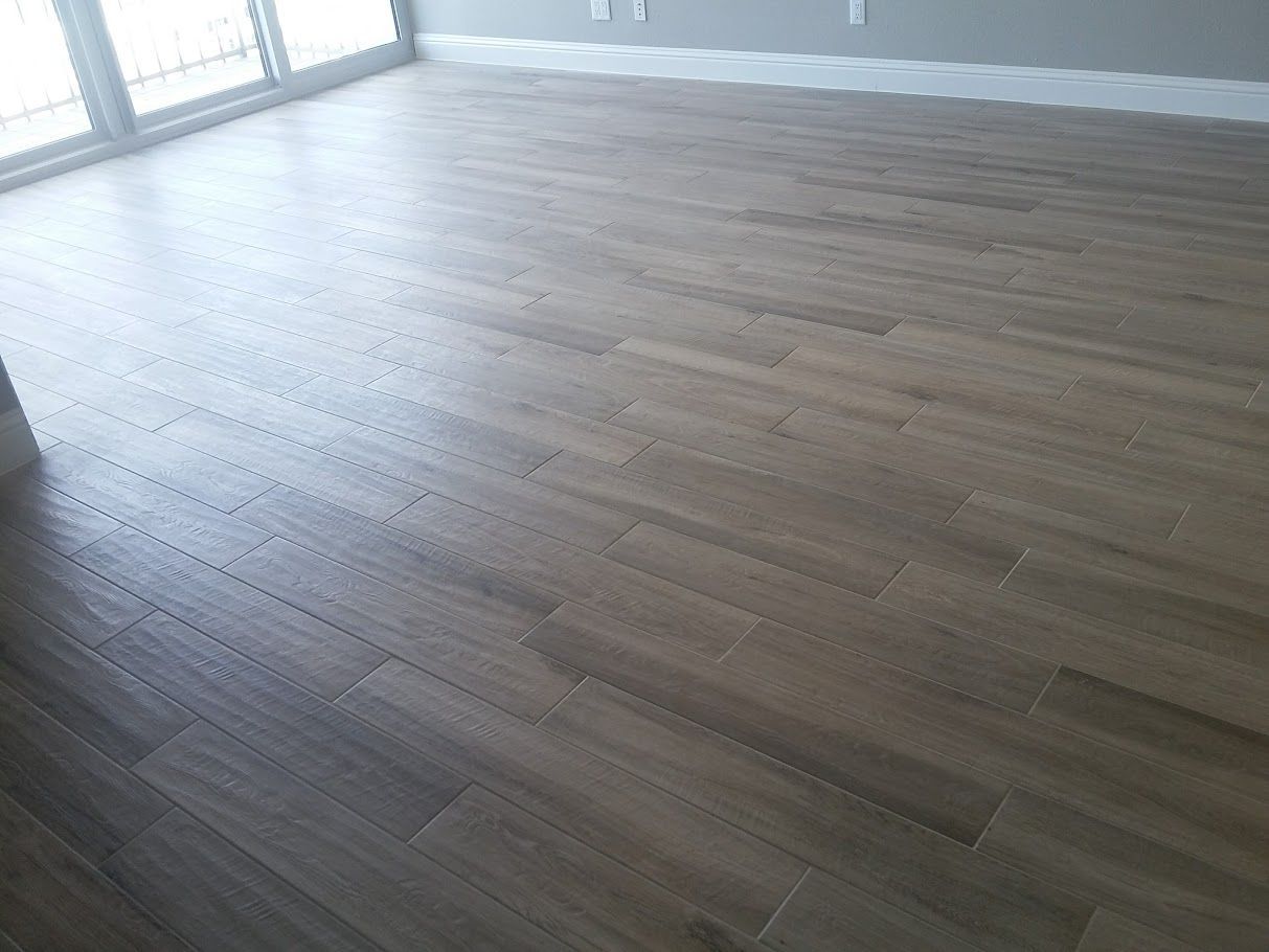 A living room with a wooden floor and a lot of windows.
