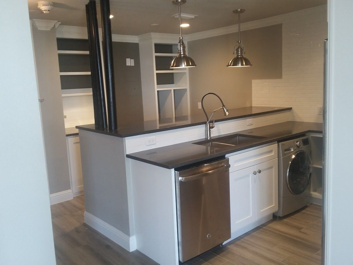 A kitchen with a sink and a washer and dryer.