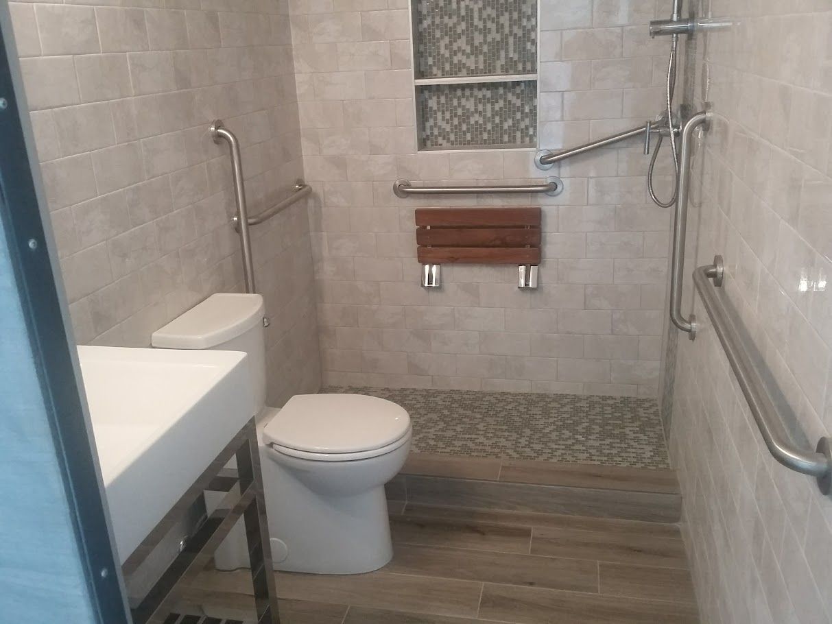 A bathroom with a toilet , sink and shower.