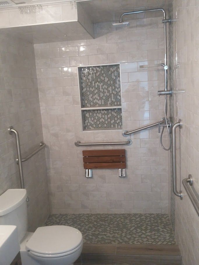 A bathroom with a toilet , sink and shower.