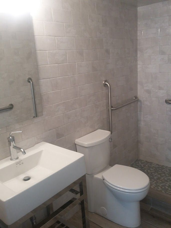 A bathroom with a toilet a sink and a mirror