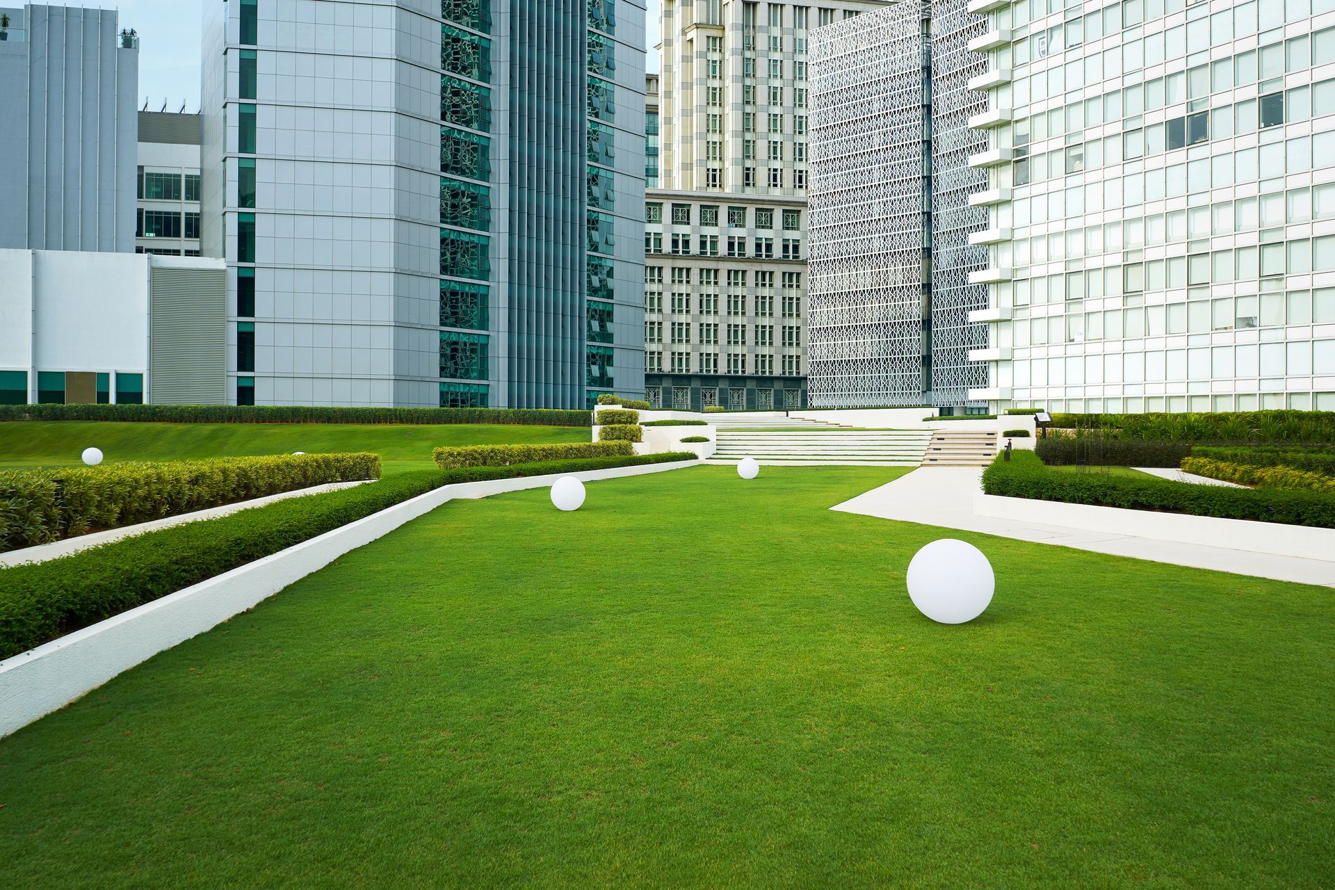 a lush green lawn surrounded by tall buildings