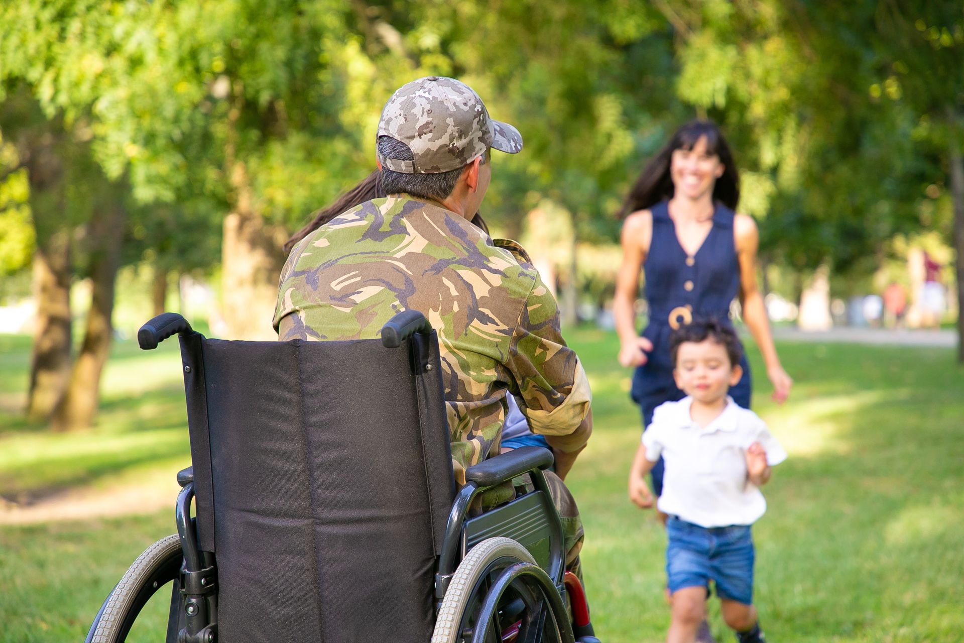 two-happy-kids-their-mom-running-toward-disabled-retired-military-father-hugging-him