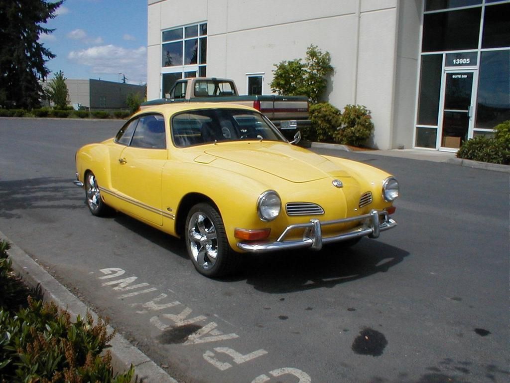 A yellow car is parked in a no parking zone