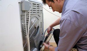 Washers — Man Repairing the Dryer in Wichita, KS