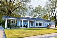 A light blue building with a carport, sign that says 