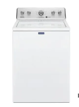 A white washing machine is sitting on top of a white counter.