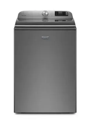 A gray washing machine is sitting on a white surface.