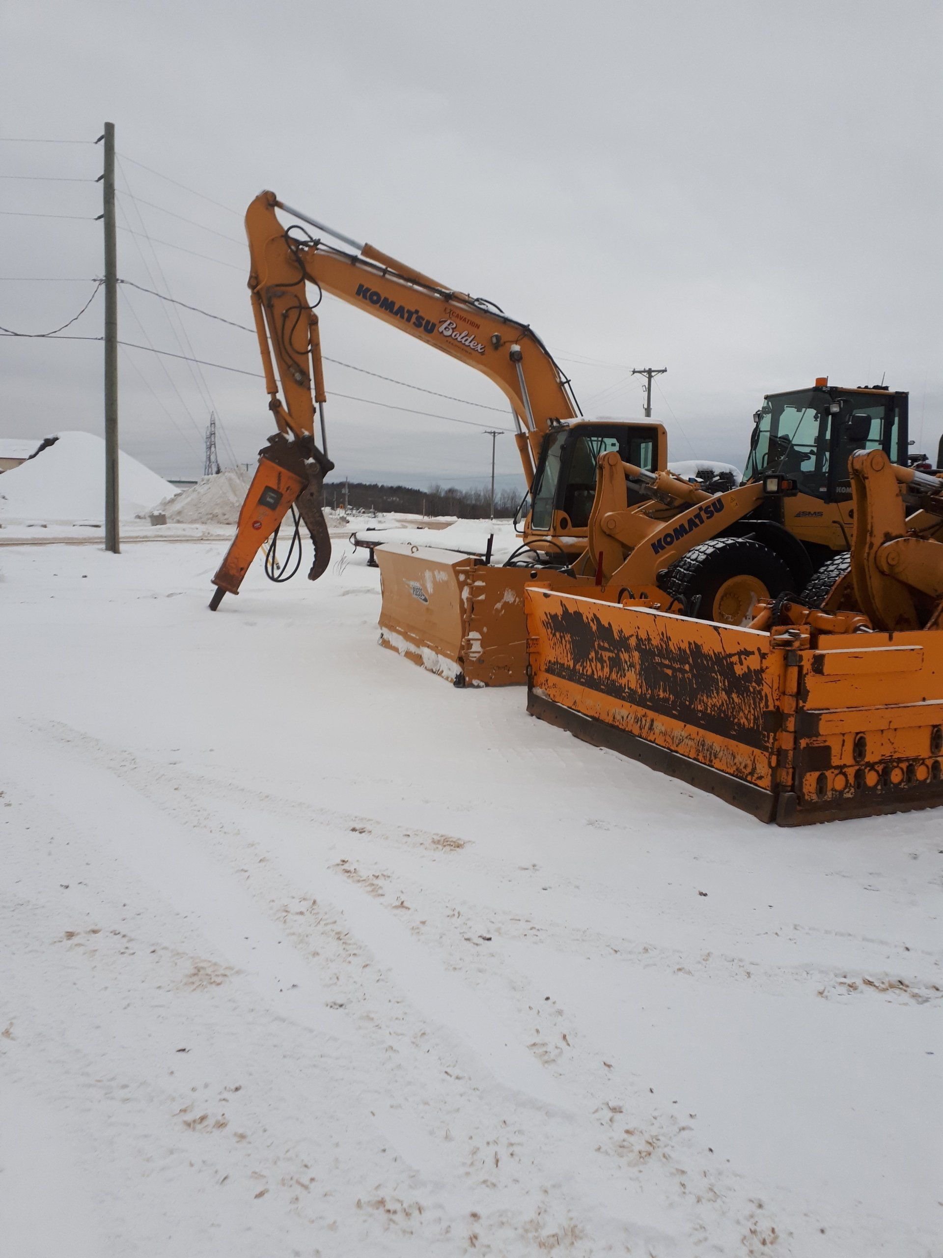 Une grande pelle jaune est garée dans la neige