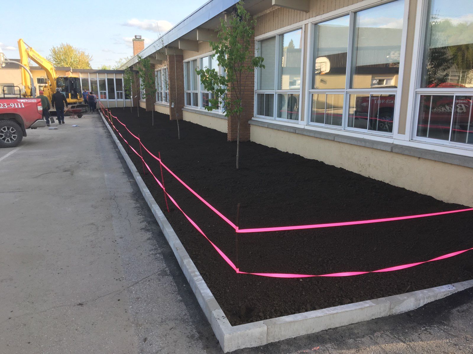 Un camion rouge est garé devant un immeuble