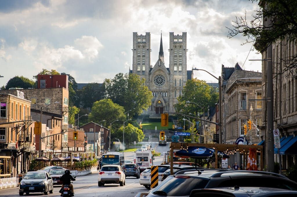 Street view with cars and a large church in the distance.