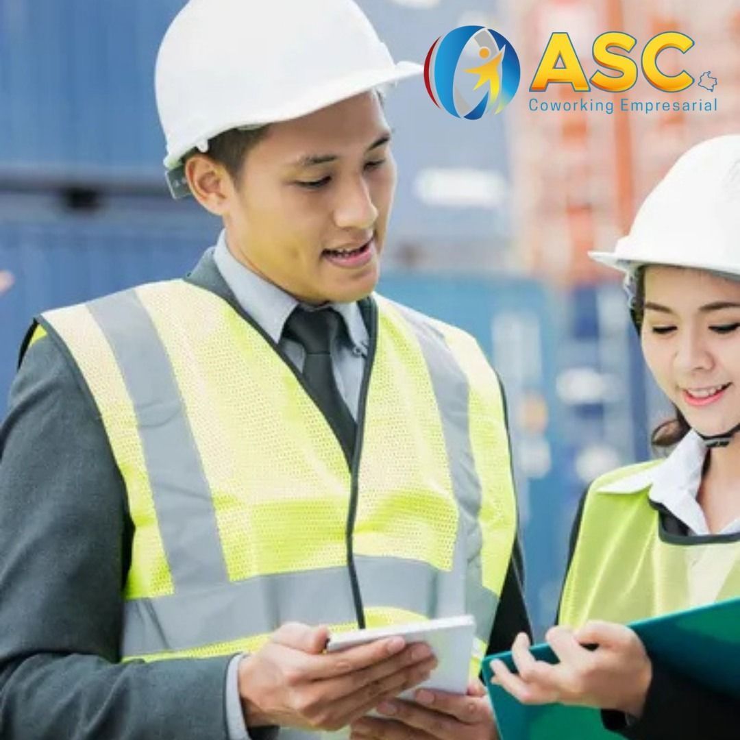 Dos profesionales con cascos y chalecos de seguridad están de pie en un astillero