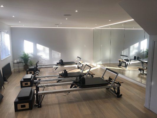 A Pilates studio with a mirror and Pilates exercise equipment