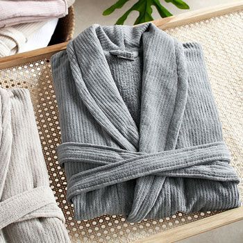 Albornoz blanco colgado en una percha de madera.