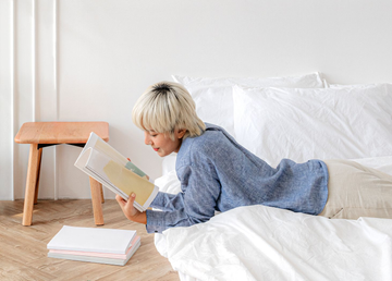 Outdoor patio with tables, chairs, and pool, surrounded by apartment buildings, under a blue sky.