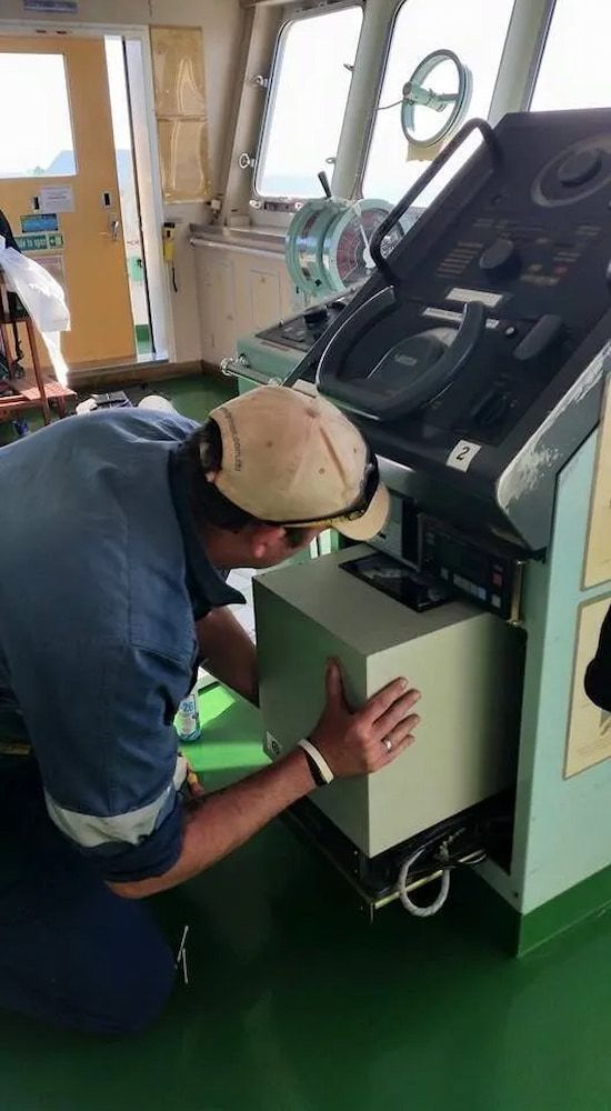 A Man is Kneeling Down in Front of a Control Panel on a Ship — Seabourne Electronics PTY Ltd in Railway Estate, QLD