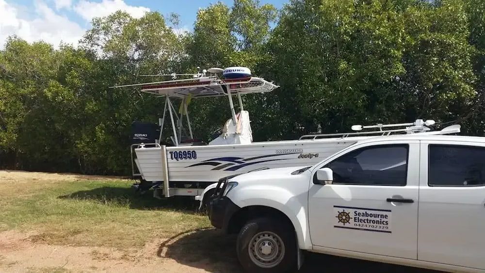 A White Truck is Parked Next to a Boat on a Trailer — Seabourne Electronics PTY Ltd in Railway Estate, QLD