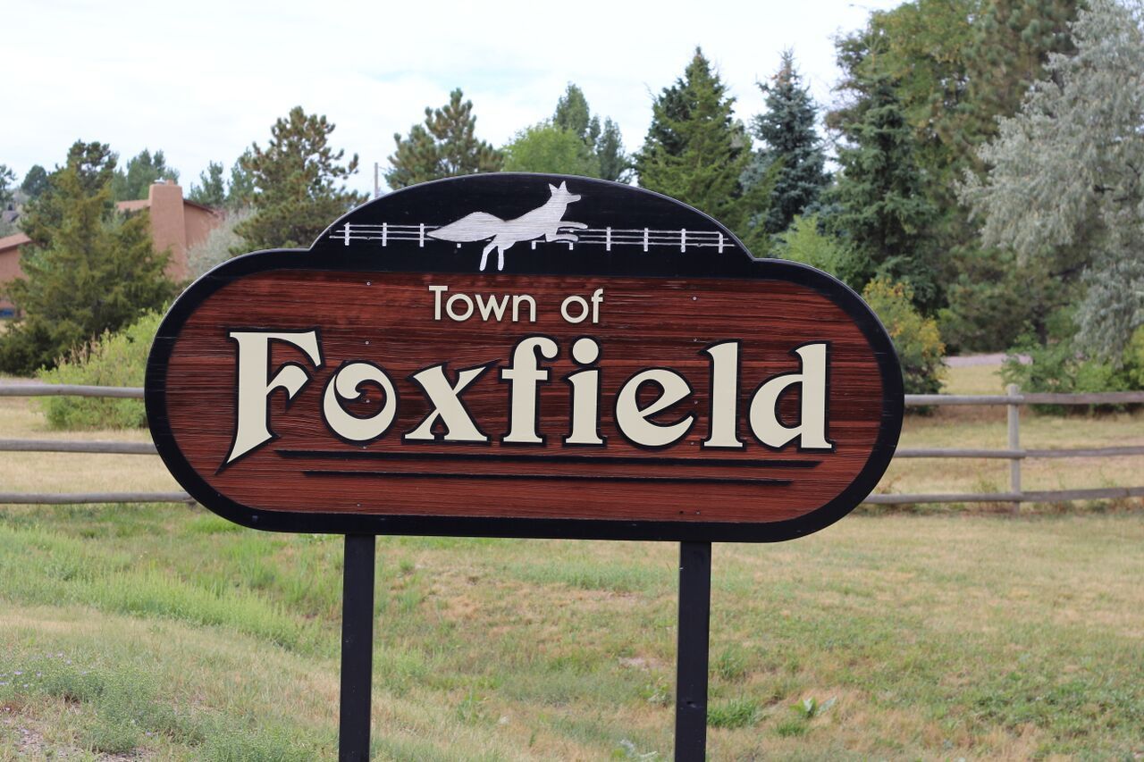 Sign for the Town of Foxfield, Colorado, featuring a fox silhouette and wooden design.