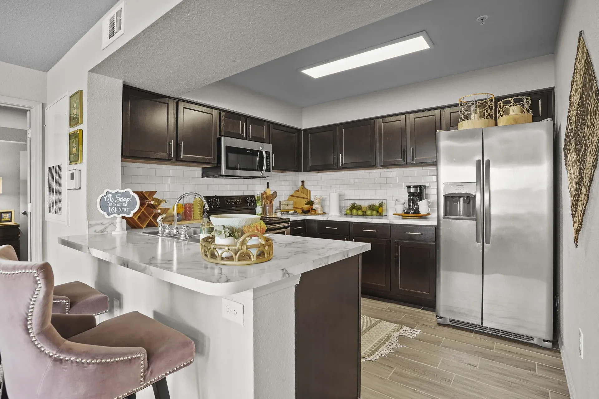 A kitchen with a white island and a refrigerator.