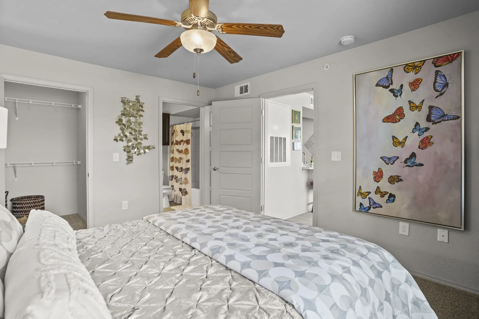 A bedroom with a large bed and a painting on the wall.