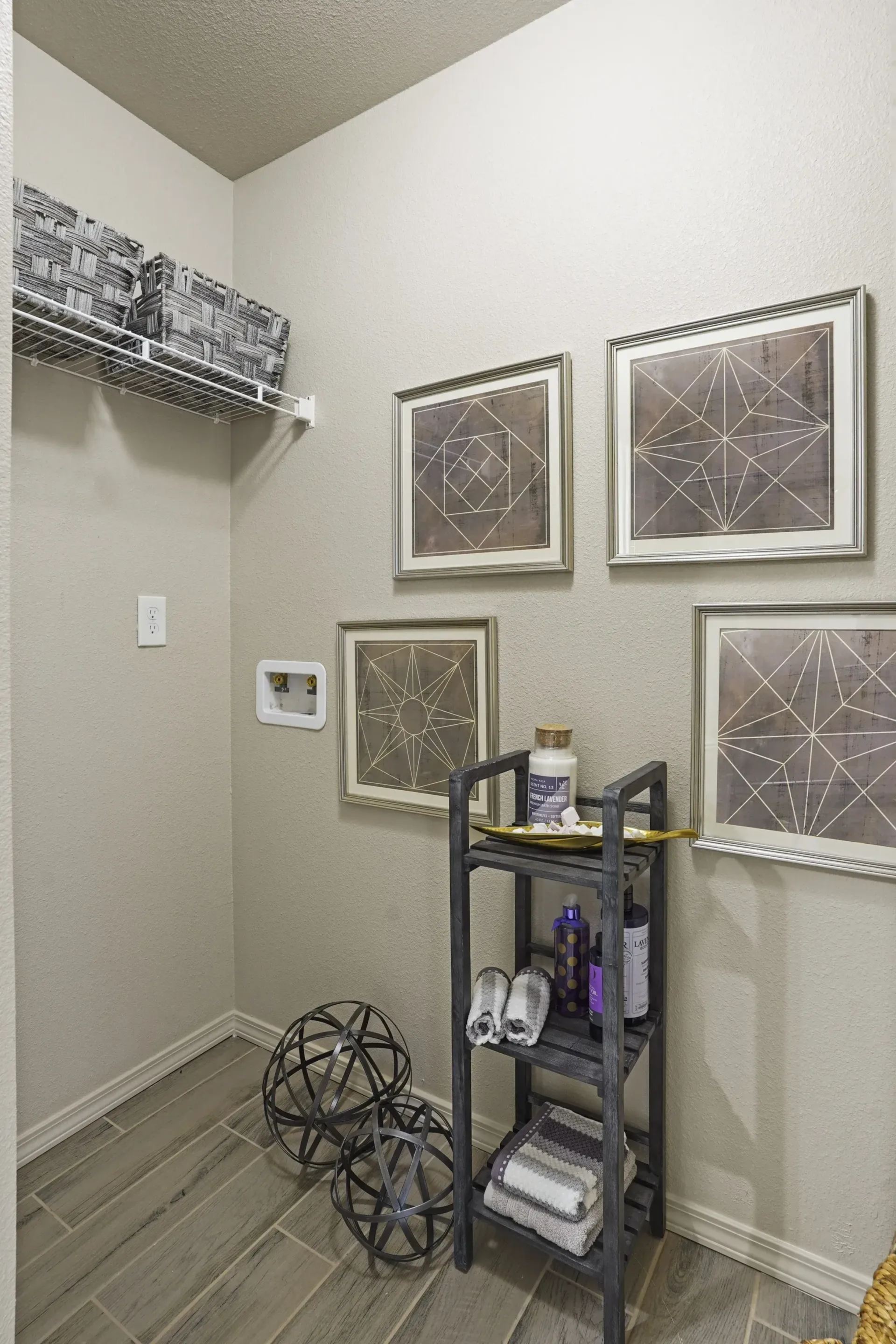 A bathroom with a shelf and two framed pictures on the wall.