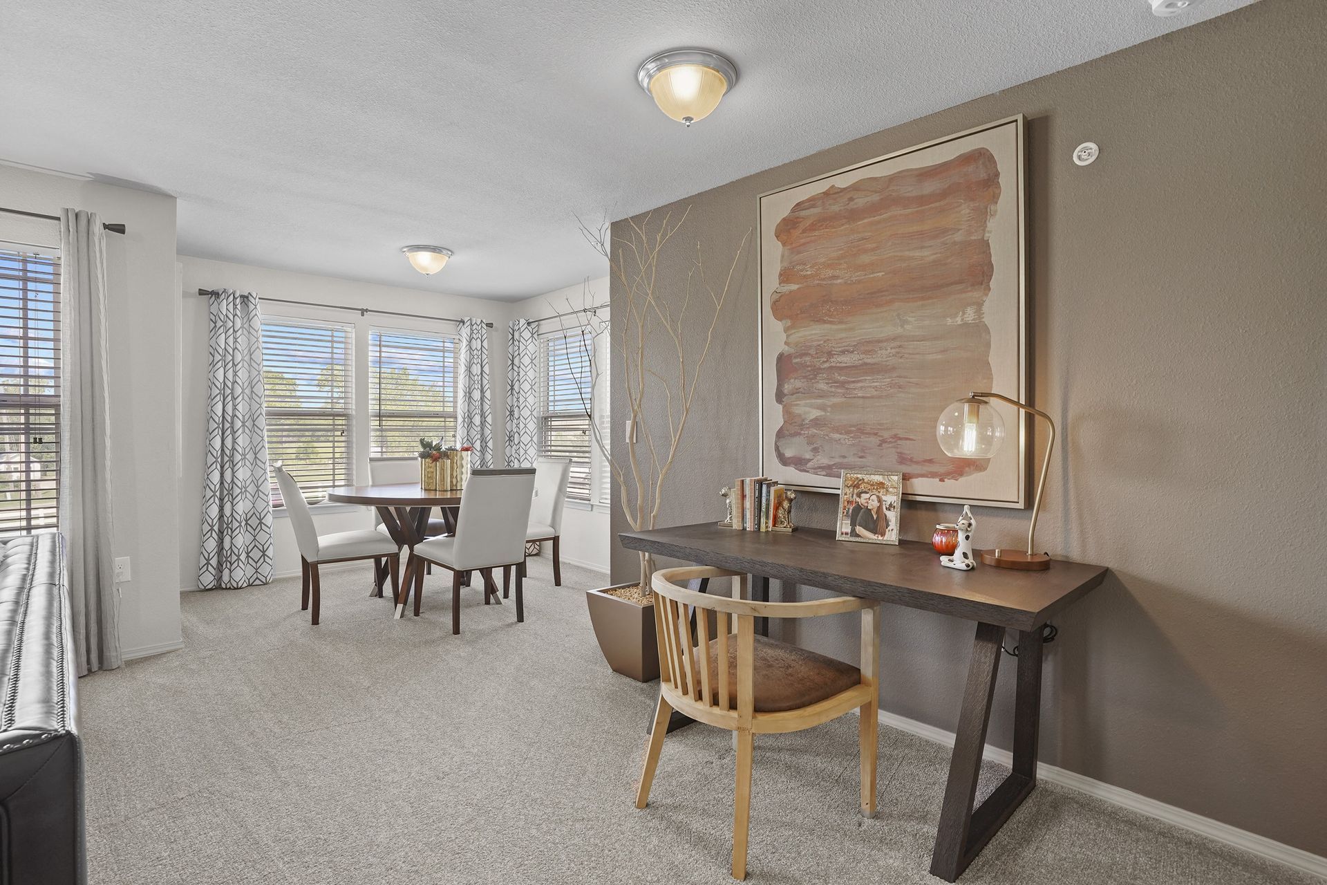 A room with a dining table and chairs.