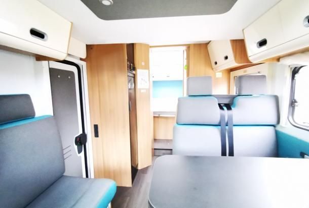 The inside of a camper van with a table and chairs