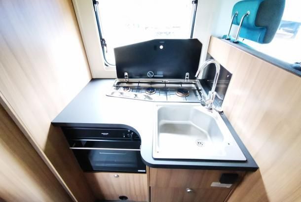 A small kitchen with a sink stove and oven