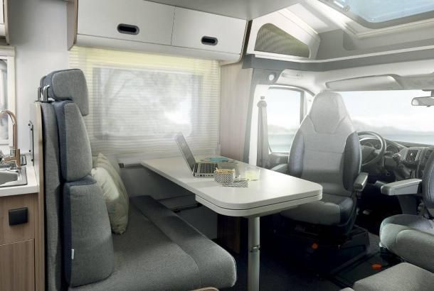 The inside of a camper van with a table and chairs.