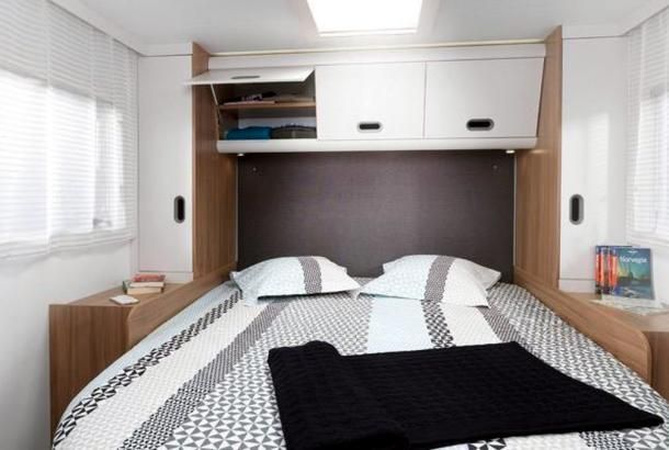 A bedroom with a bed and a book on the nightstand