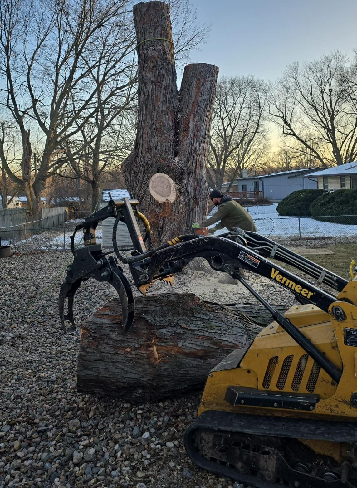 A man is cutting a tree stump with a machine.