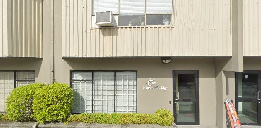 Exterior of a building with multiple windows and a door. Signage reads 