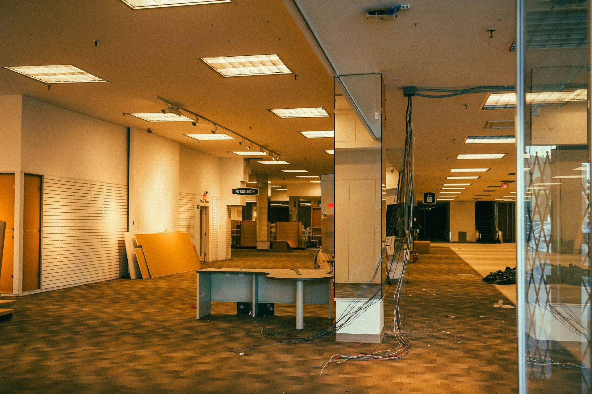 Interior view of an empty commercial space with exposed wiring and partially finished construction.