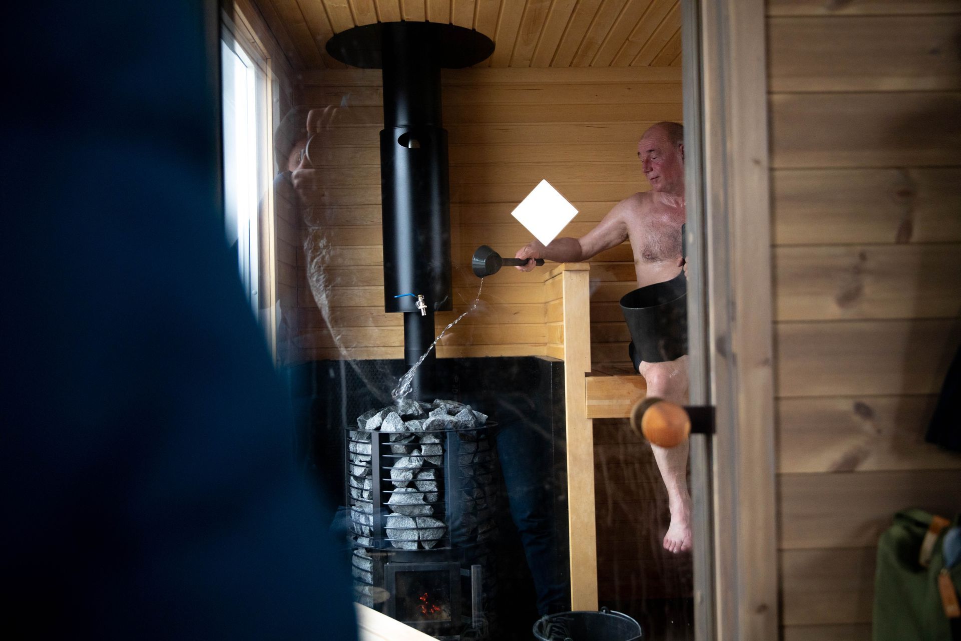 En mann hiver vann på en saunaovn.