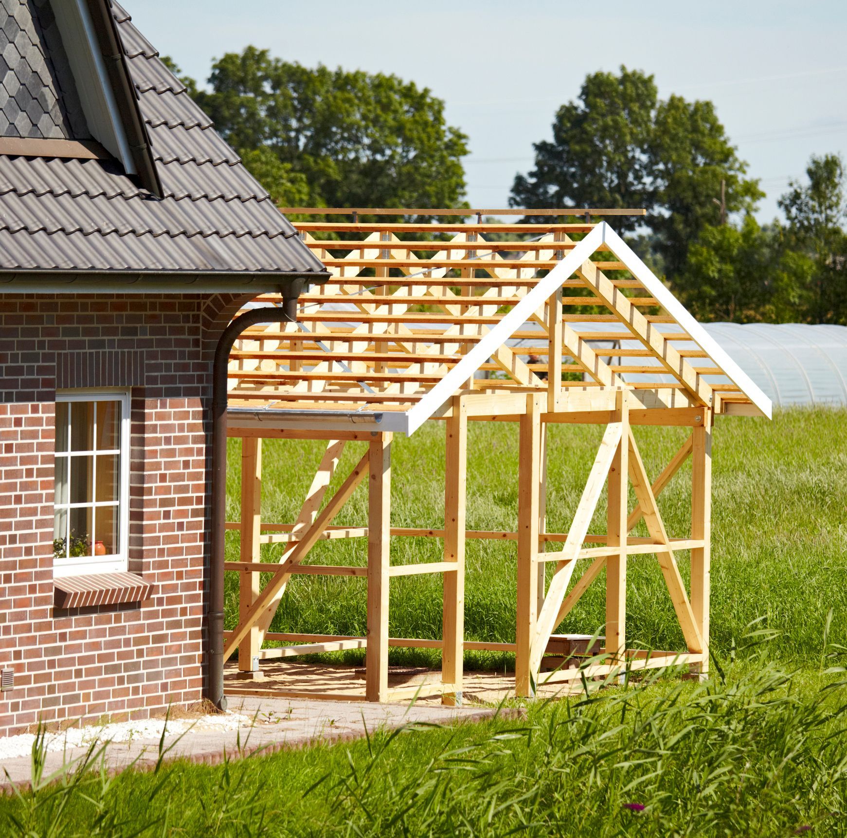 A brick house with a wooden structure in front of it