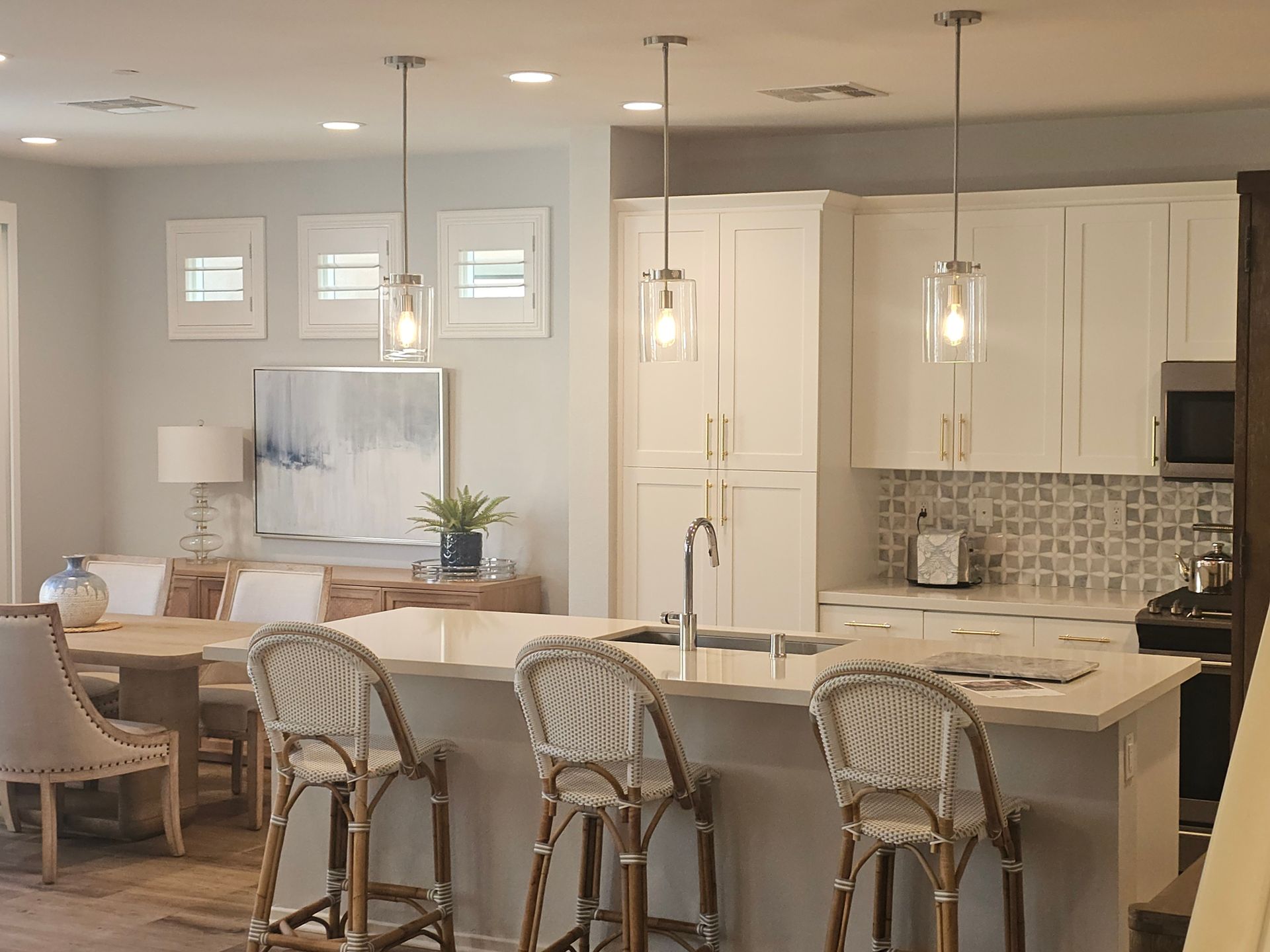 A kitchen with a large island and wicker chairs