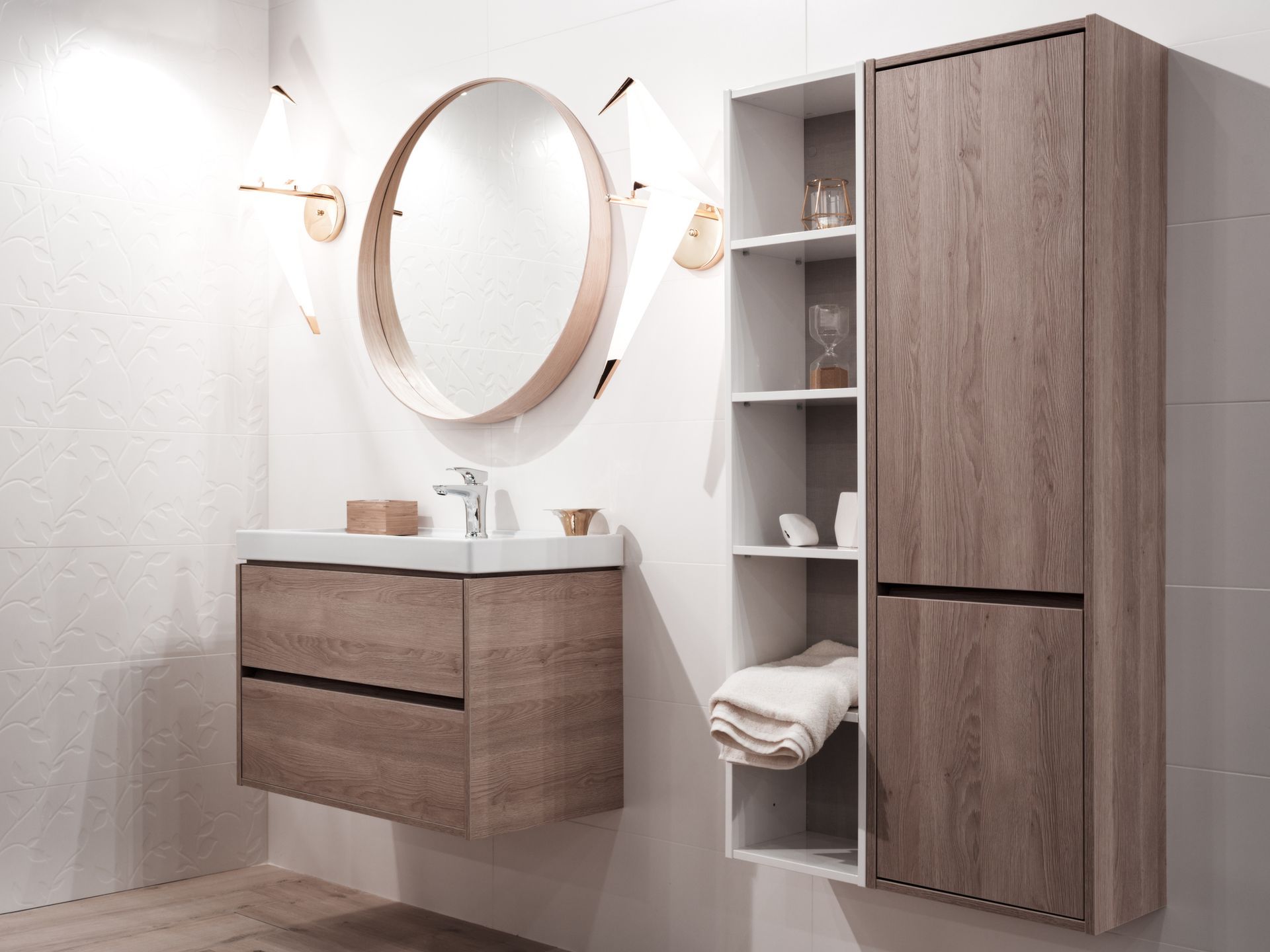 A bathroom with a sink , mirror , cabinets and shelves.