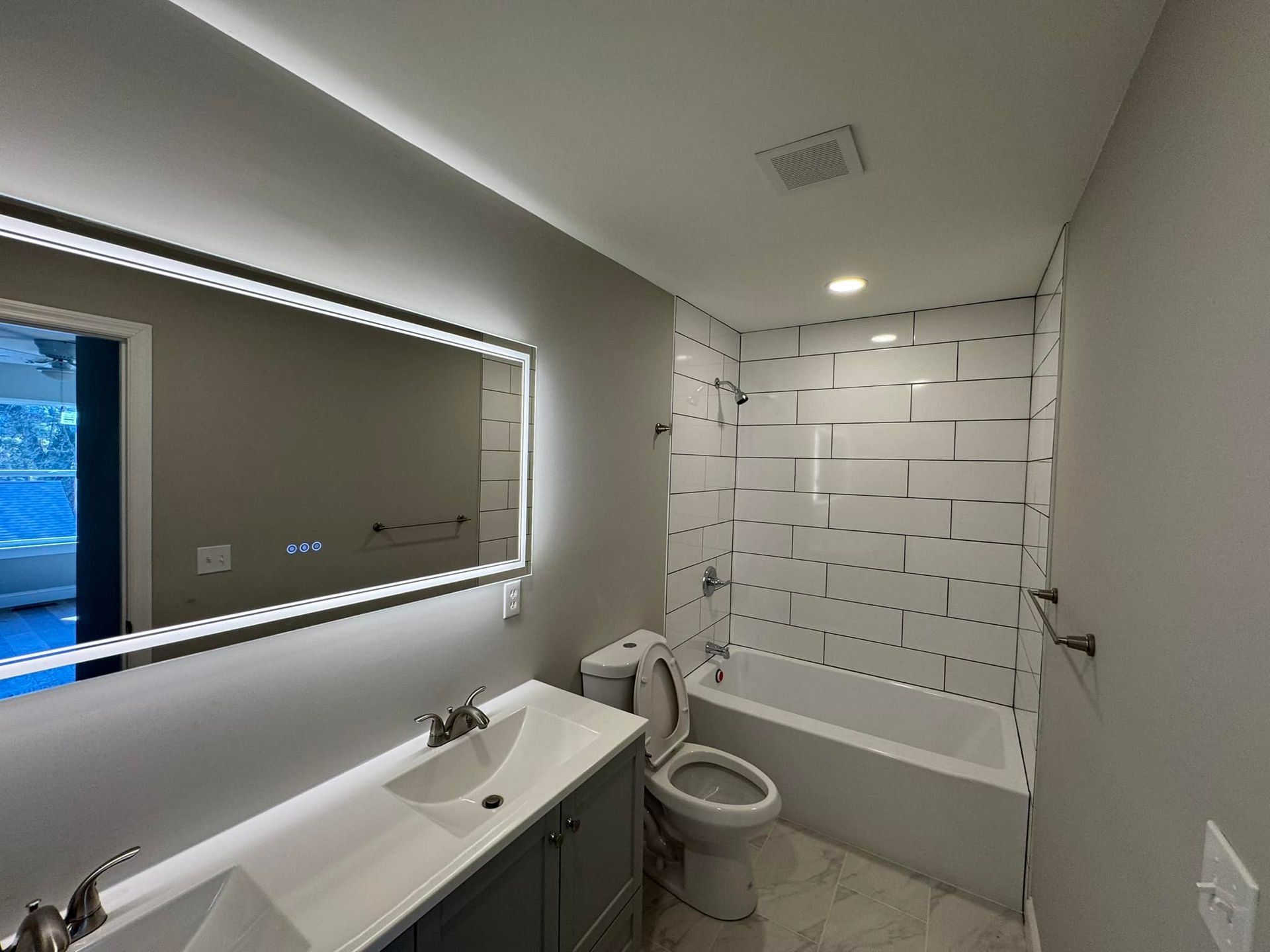 A bathroom with a toilet , sink , and bathtub.