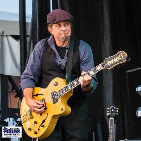 JP Soars playing a yellow guitar on stage