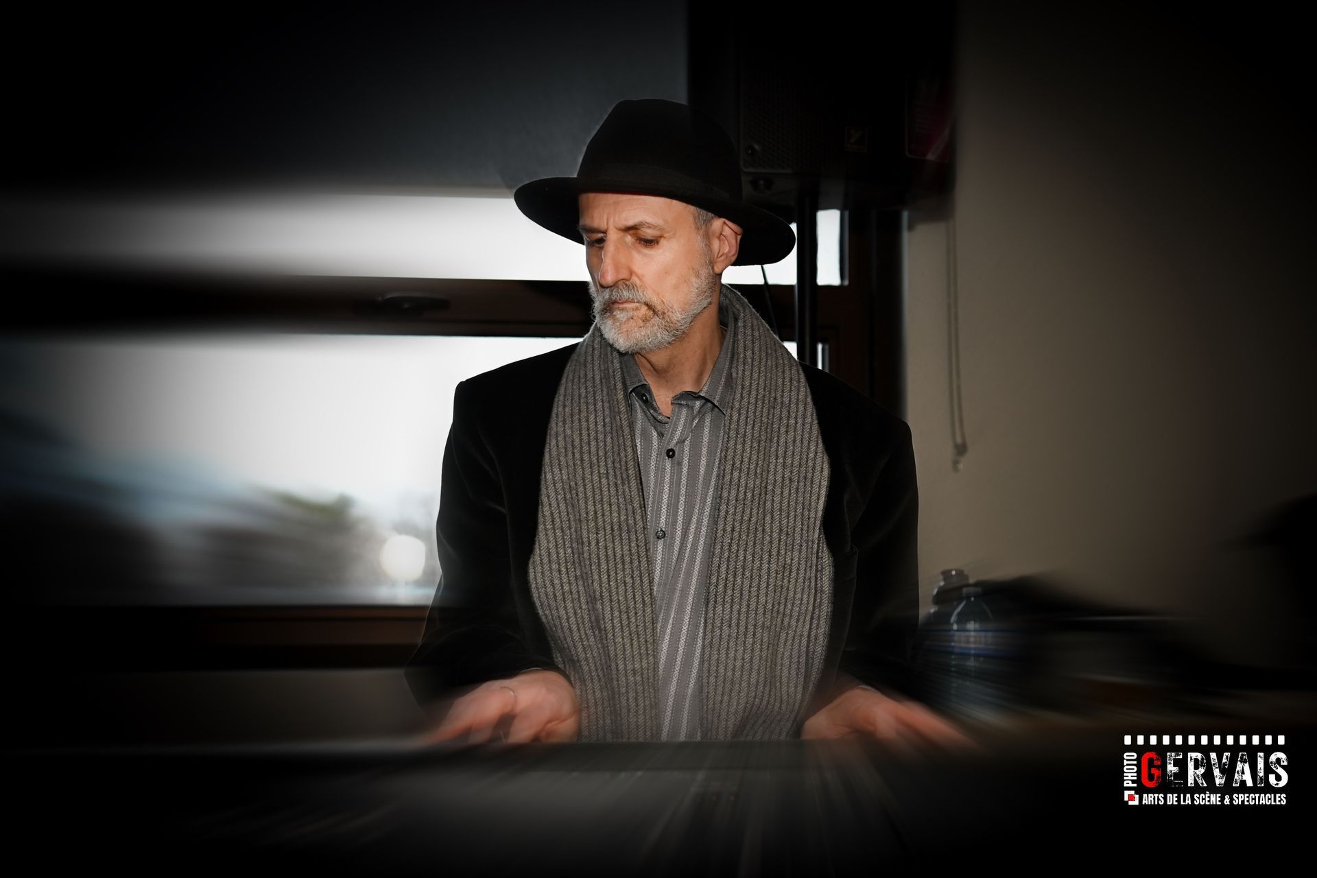 A man wearing a black hat playing a keyboard