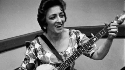 Woman smiling, playing guitar