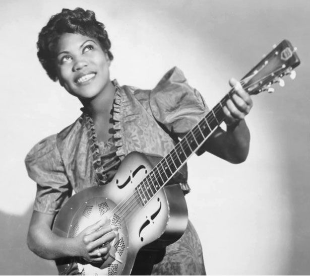 Woman smiling, playing guitar